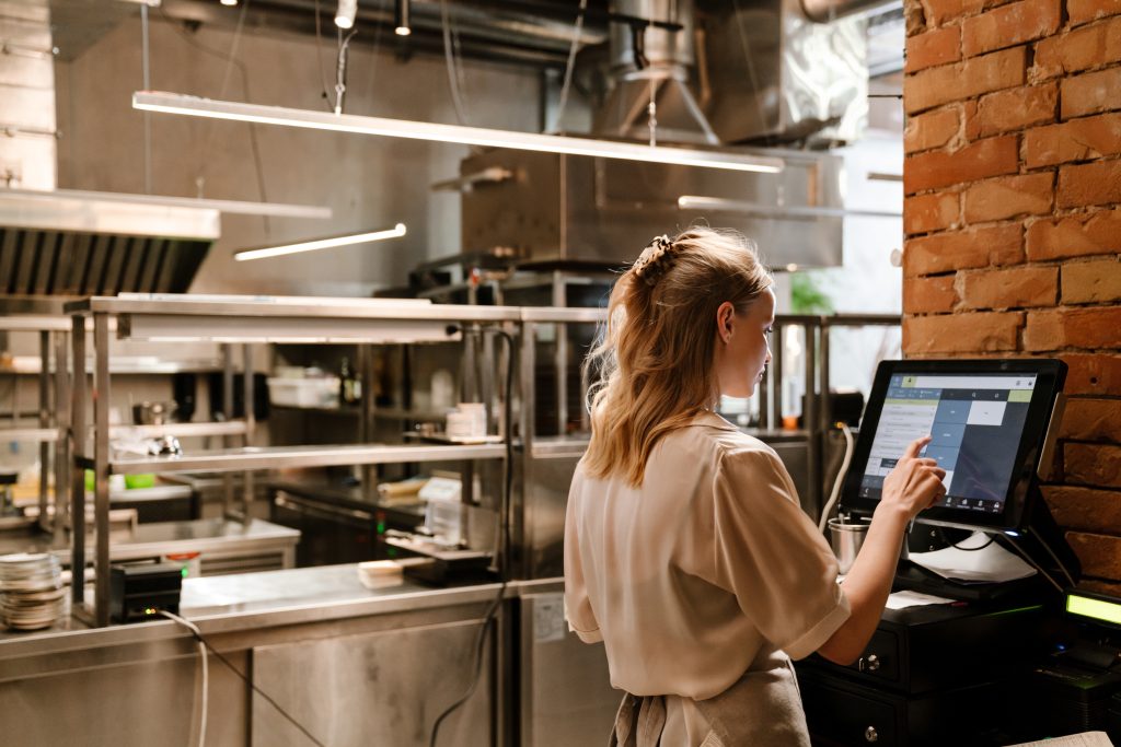 A foodservice manager transitioning from a chaotic paper invoice system to a streamlined dashboard tracking the end-to-end procure-to-pay process in a modern commercial kitchen environment.
